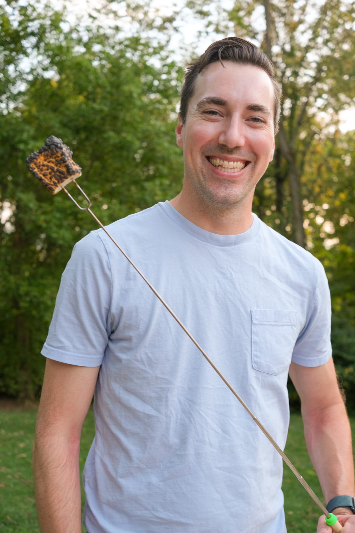 Andrew Baker holding a burnt marshmallow on a stick